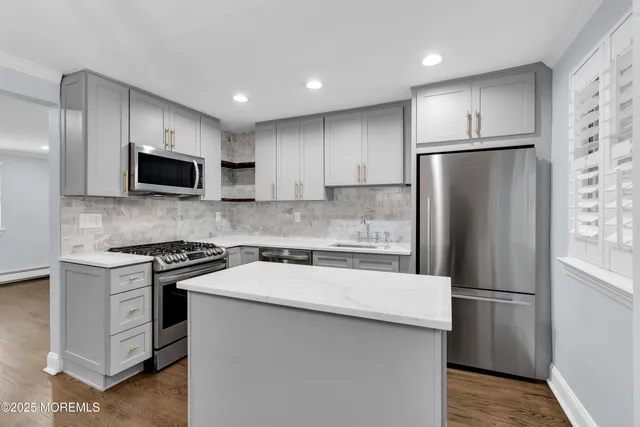 a kitchen with stainless steel appliances a refrigerator stove and microwave