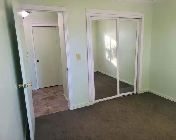 an empty room with closet and mirror