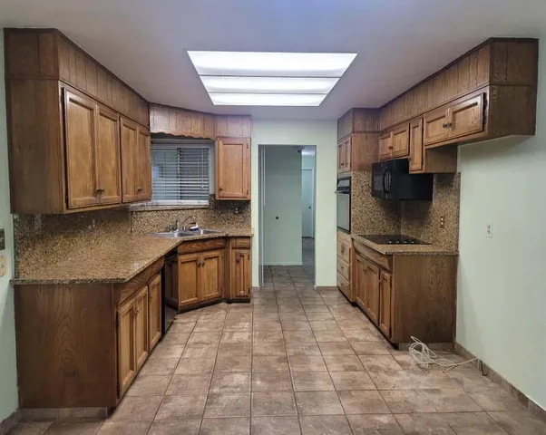 a kitchen with stainless steel appliances granite countertop a stove a sink and a microwave