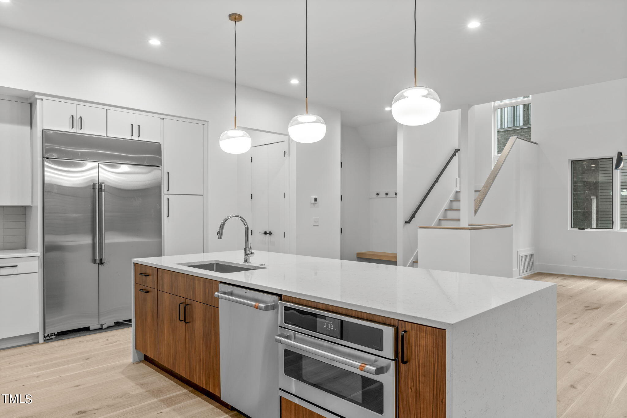 a kitchen that has a sink a refrigerator a stove and cabinets