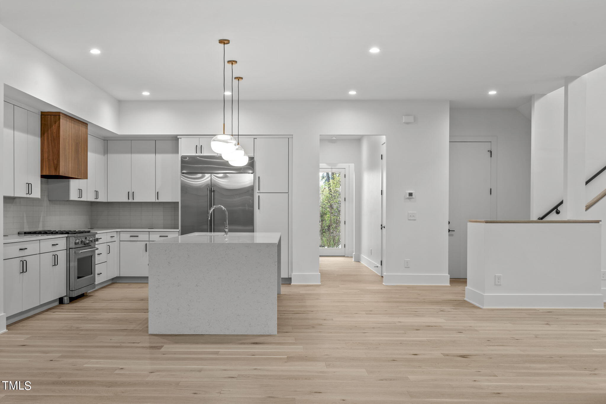 1406 Lyon Street, Unit 102 Raleigh, NC 27608 - Photo 13 of 57 a large kitchen with stainless steel appliances granite countertop a refrigerator a oven and a wooden floors