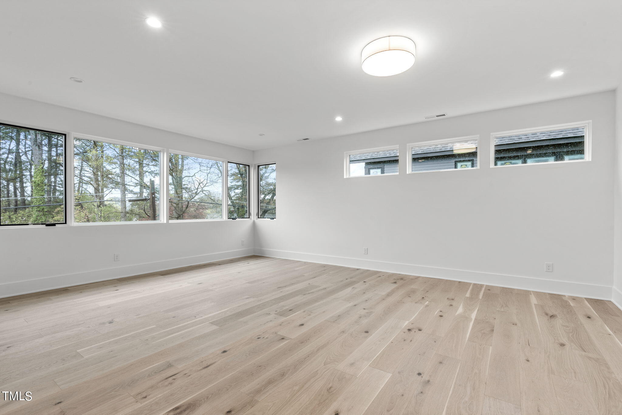 1406 Lyon Street, Unit 102 Raleigh, NC 27608 - Photo 18 of 57 an empty room with wooden floor and windows
