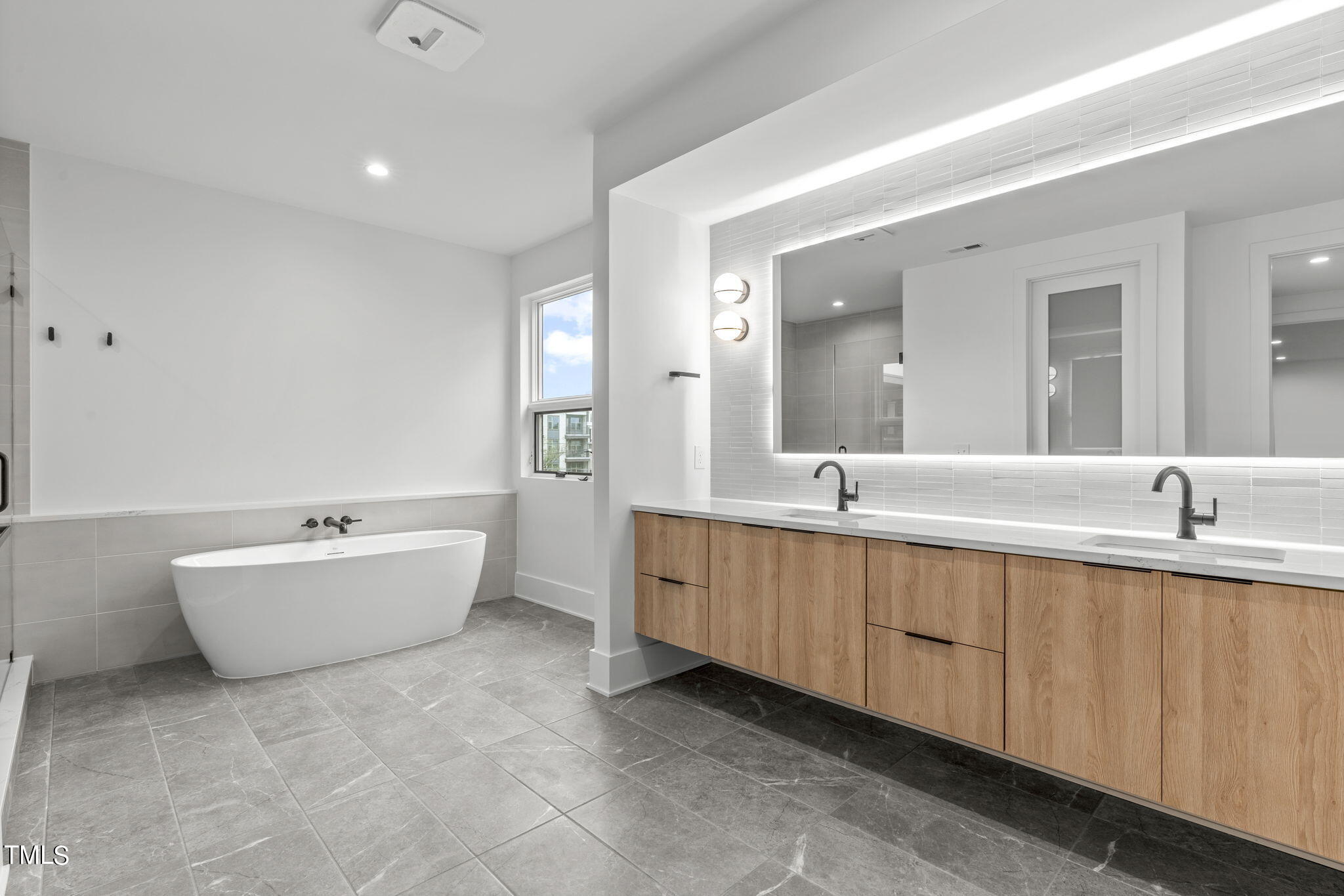 1406 Lyon Street, Unit 102 Raleigh, NC 27608 - Photo 20 of 57 a bathroom with a bathtub sink and mirror