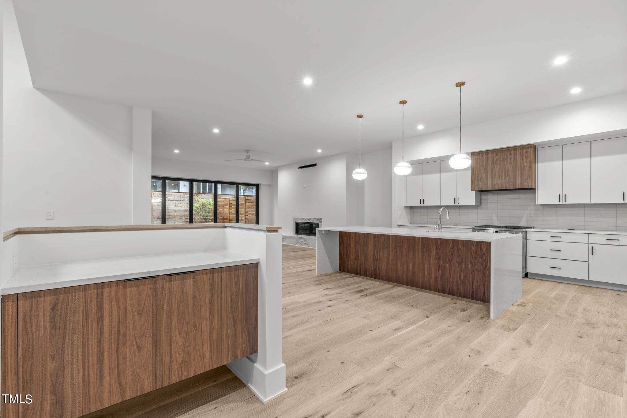 1406 Lyon Street, Unit 102 Raleigh, NC 27608 - Photo 2 of 57 a large kitchen with kitchen island granite countertop wooden cabinets a sink and a stove
