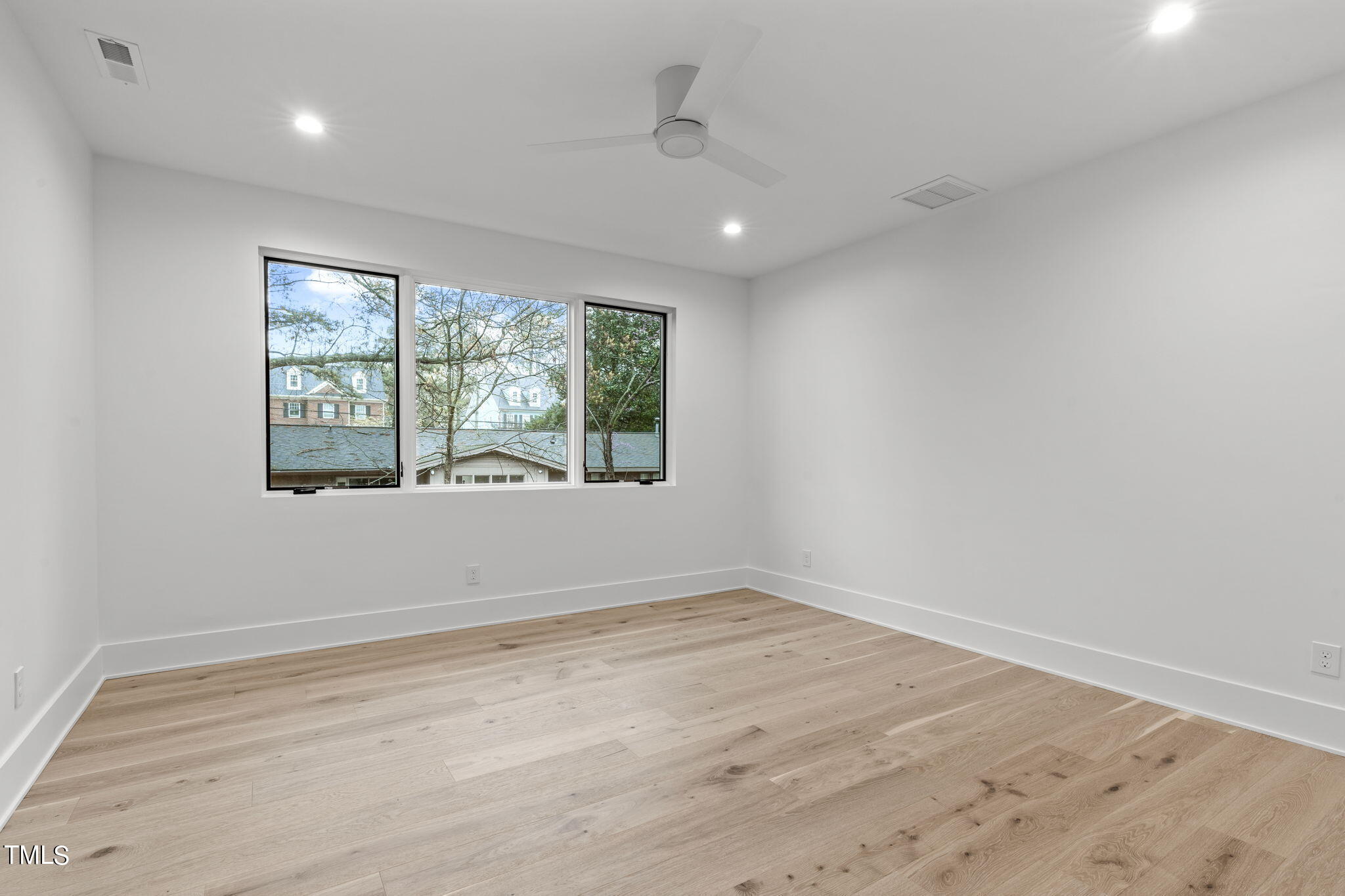 1406 Lyon Street, Unit 102 Raleigh, NC 27608 - Photo 26 of 57 an empty room with wooden floor and windows