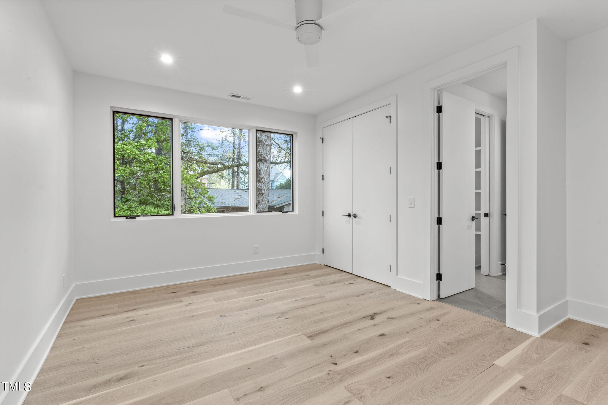 1406 Lyon Street, Unit 102 Raleigh, NC 27608 - Photo 29 of 57 a view of an empty room with wooden floor and a window
