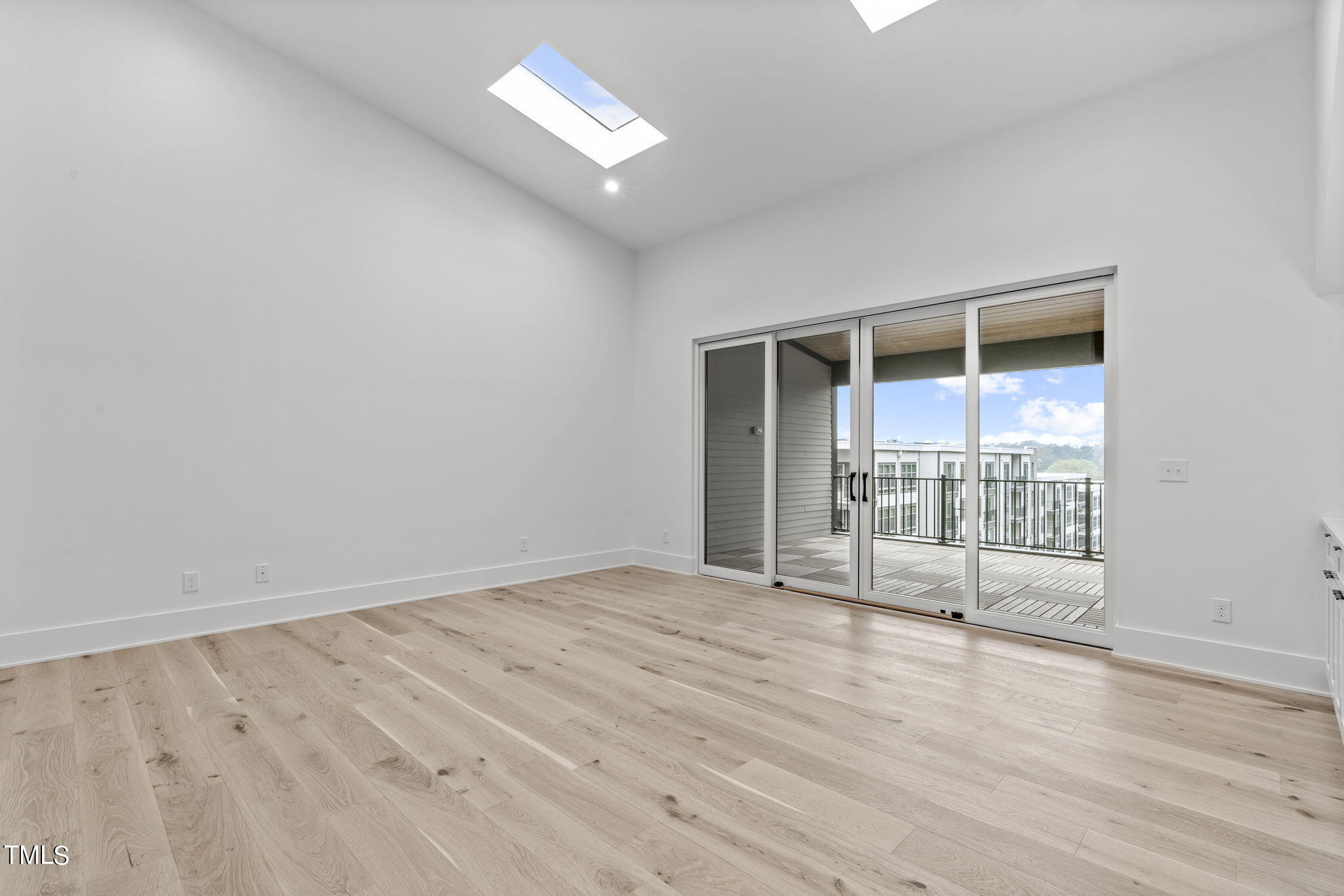1406 Lyon Street, Unit 102 Raleigh, NC 27608 - Photo 32 of 57 an empty room with wooden floor and windows