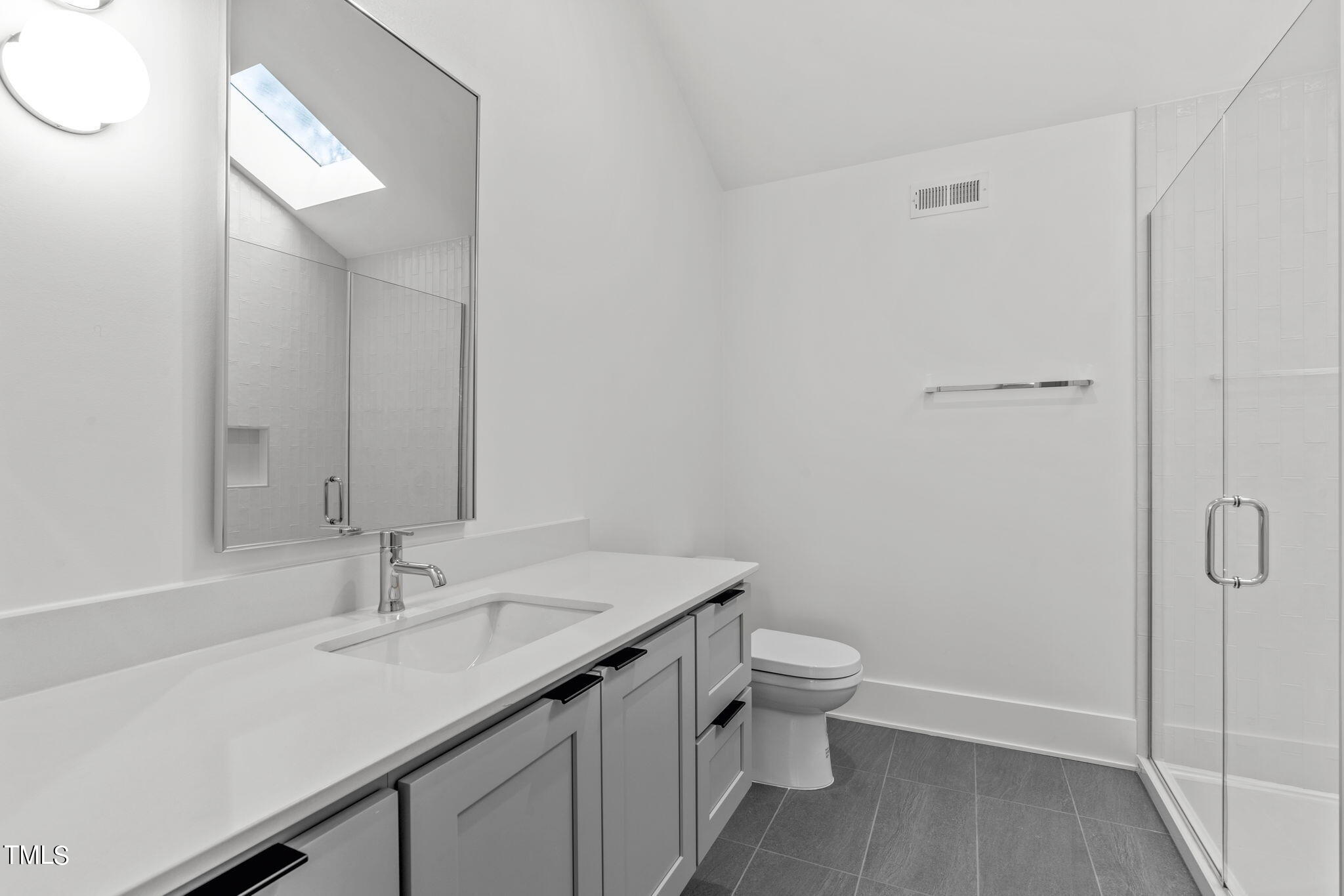 1406 Lyon Street, Unit 102 Raleigh, NC 27608 - Photo 37 of 57 a bathroom with a sink a toilet and shower