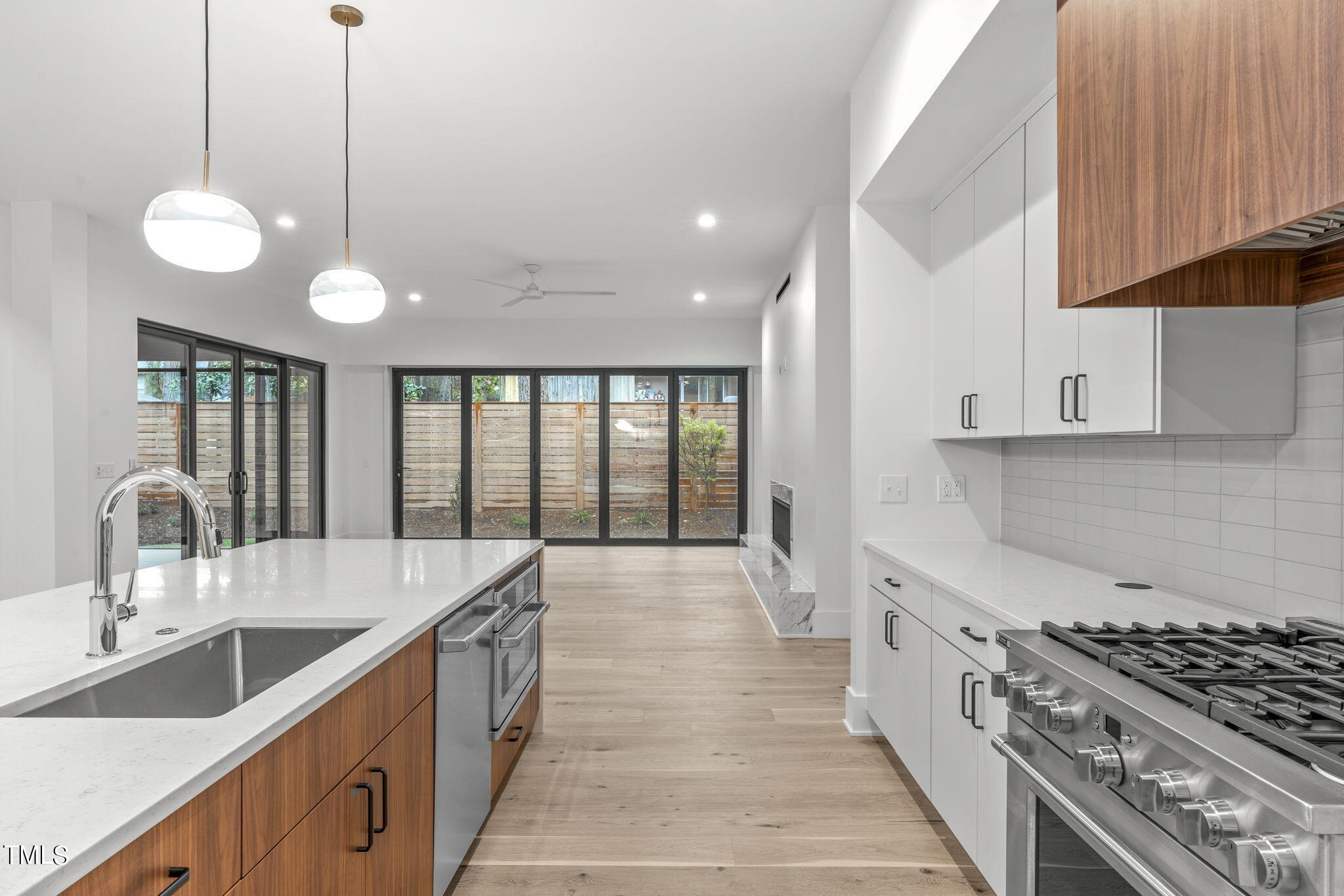 1406 Lyon Street, Unit 102 Raleigh, NC 27608 - Photo 5 of 57 a kitchen with stainless steel appliances granite countertop a sink a stove and a wooden floors