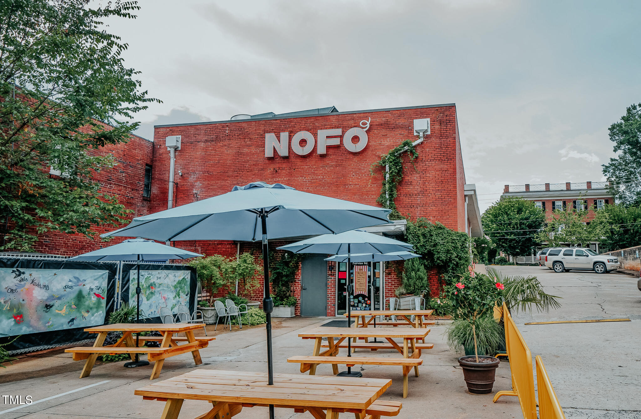 1406 Lyon Street, Unit 102 Raleigh, NC 27608 - Photo 55 of 57 an outdoor space with patio furniture and white umbrellas