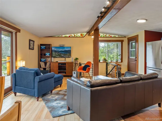 a living room with furniture a flat screen tv and a floor to ceiling window