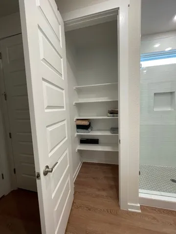 a view of a hallway with wooden floor and staircase