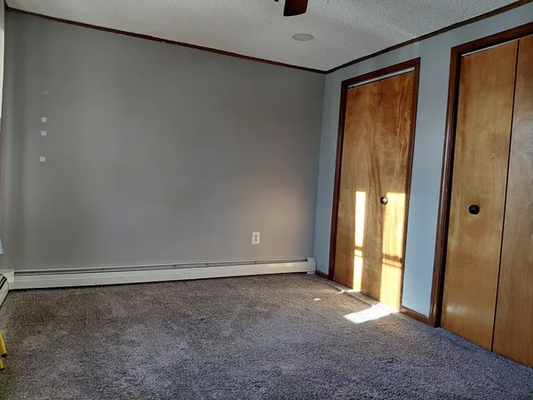 an empty room with closet and wooden floor