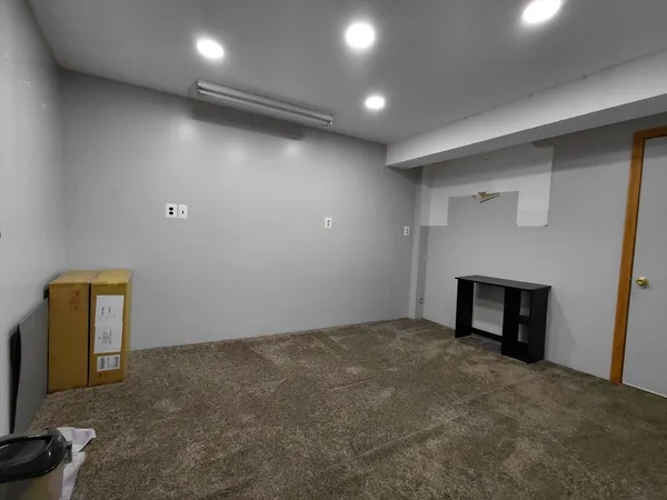 an empty room with windows and fireplace