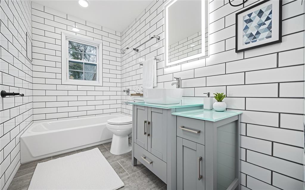 1 Lamar Avenue Southwest Atlanta, GA 30310 - Photo 10 of 11 a bathroom with a granite countertop toilet a sink and a bathtub