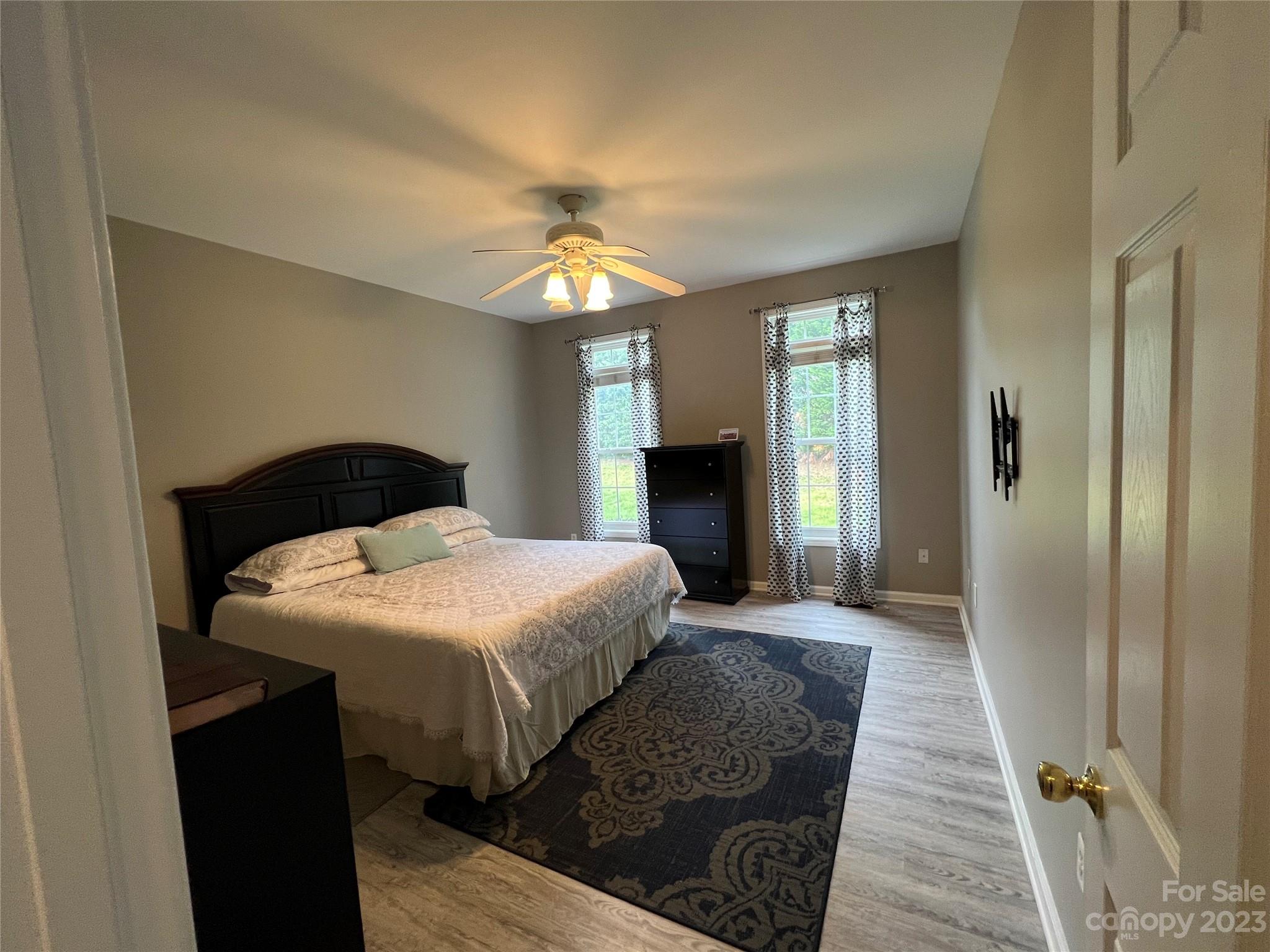 117 Forest Ridge Road Mooresville, NC 28117 - Photo 19 of 40 a bedroom with a bed and a chandelier