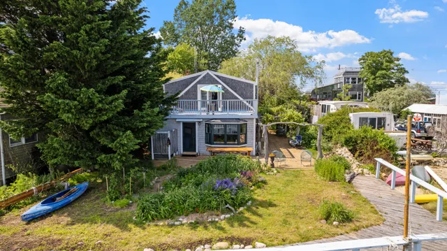 an aerial view of a house with a garden and lake view