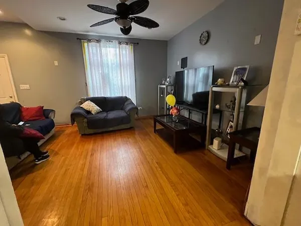 a living room with stainless steel appliances furniture a rug and a window