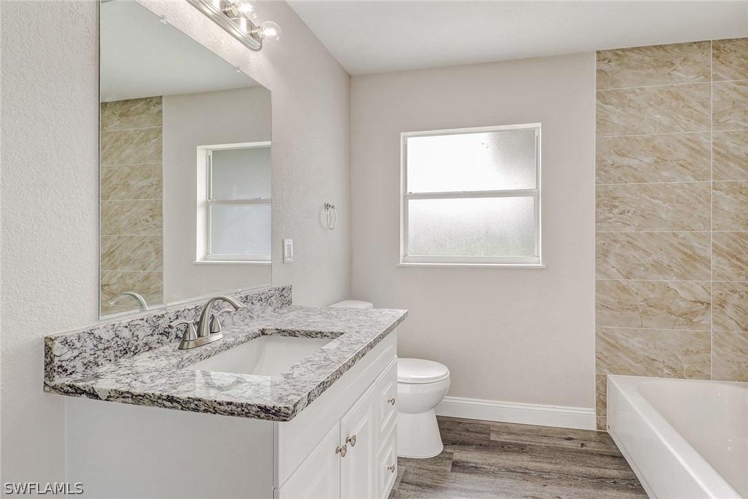 16 Connecticut Road Lehigh Acres, FL 33936 - Photo 14 of 24 a bathroom with a granite countertop sink and a mirror