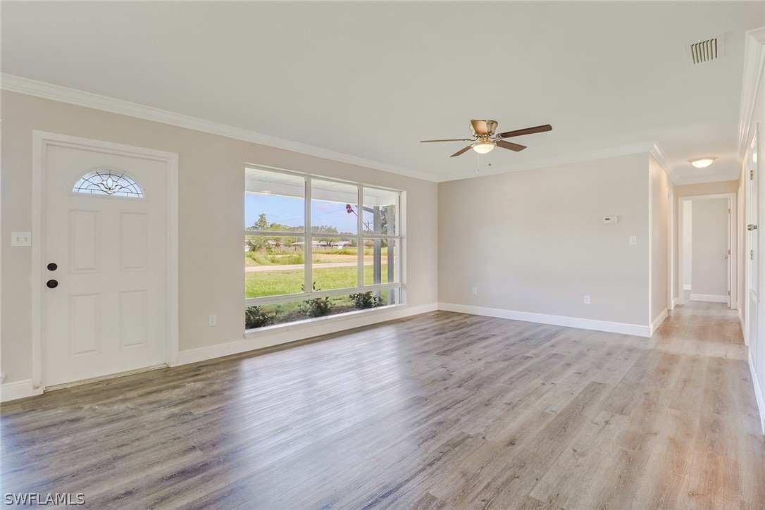 16 Connecticut Road Lehigh Acres, FL 33936 - Photo 6 of 24 wooden floor in an empty room with a window