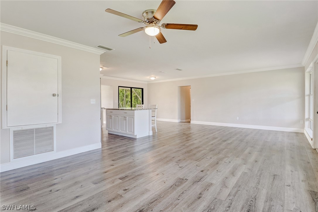 16 Connecticut Road Lehigh Acres, FL 33936 - Photo 7 of 24 wooden floor in an empty room with a window