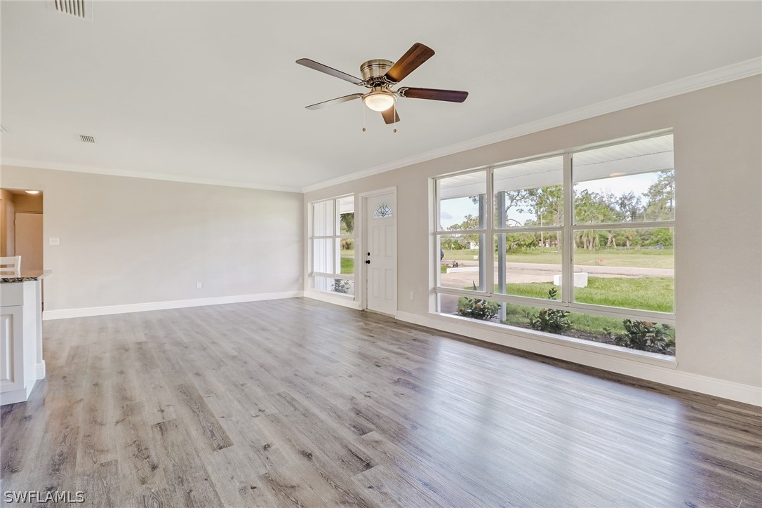 16 Connecticut Road Lehigh Acres, FL 33936 - Photo 8 of 24 a view of an empty room with wooden floor and a window