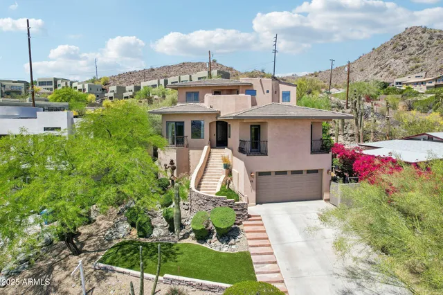 a front view of a house with a garden and trees