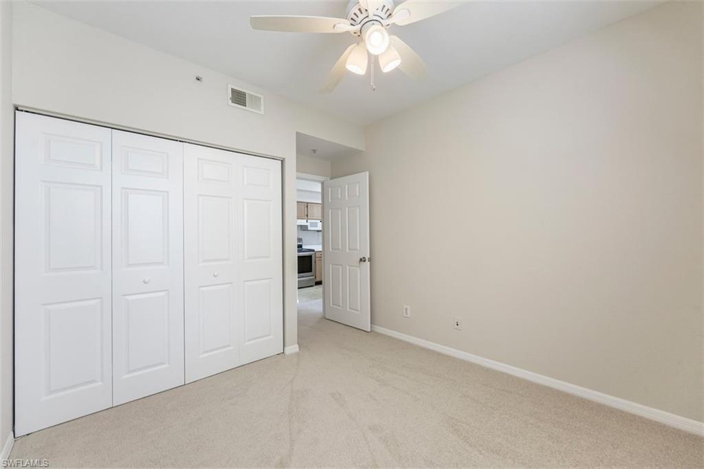 4635 St Croix Lane, Unit 1218 Naples, FL 34109 - Photo 18 of 40 Unfurnished bedroom featuring light colored carpet, a closet, and ceiling fan