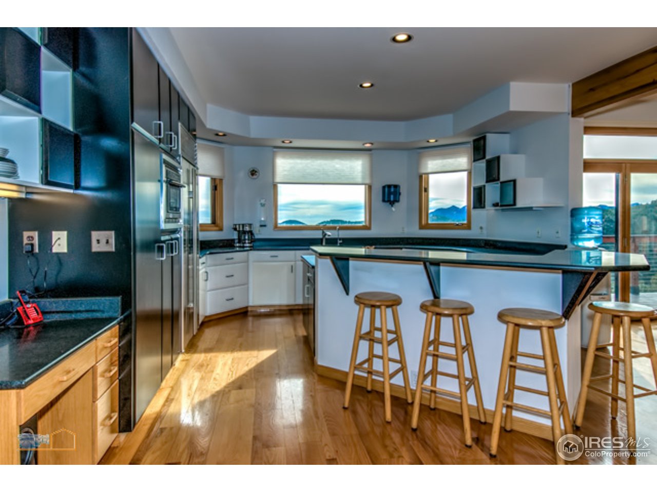 1385 West Coach Road Boulder, CO 80302 - Photo 7 of 25 a kitchen with stainless steel appliances granite countertop table chairs and chandelier
