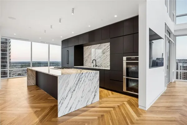 a view of kitchen with kitchen island granite countertop a refrigerator a sink and a stove top oven