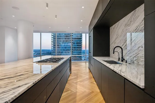 a kitchen with granite countertop sink a stove and cabinets