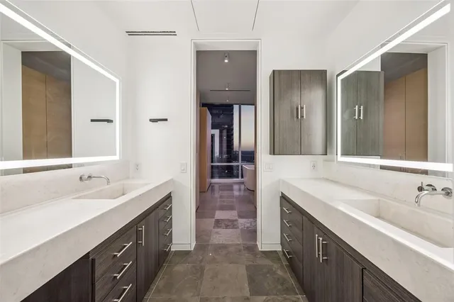 a spacious bathroom with double vanity and mirrors