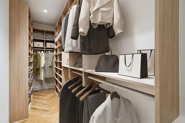 a view of walk in closet with clothes and shoes