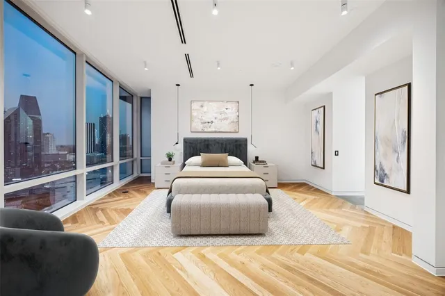 a spacious bedroom with a bed and glass walk in closet