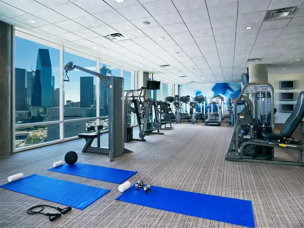 a living room with pool table and gym equipment