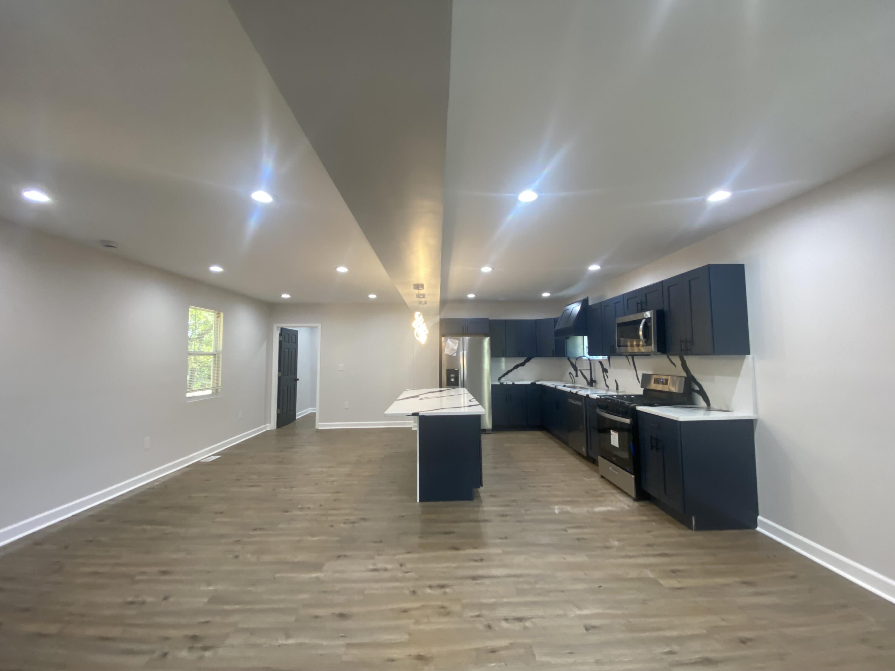 1165 Waite Street Gary, IN 46404 - Photo 7 of 18 a view of a living room and kitchen with furniture wooden floor and fan