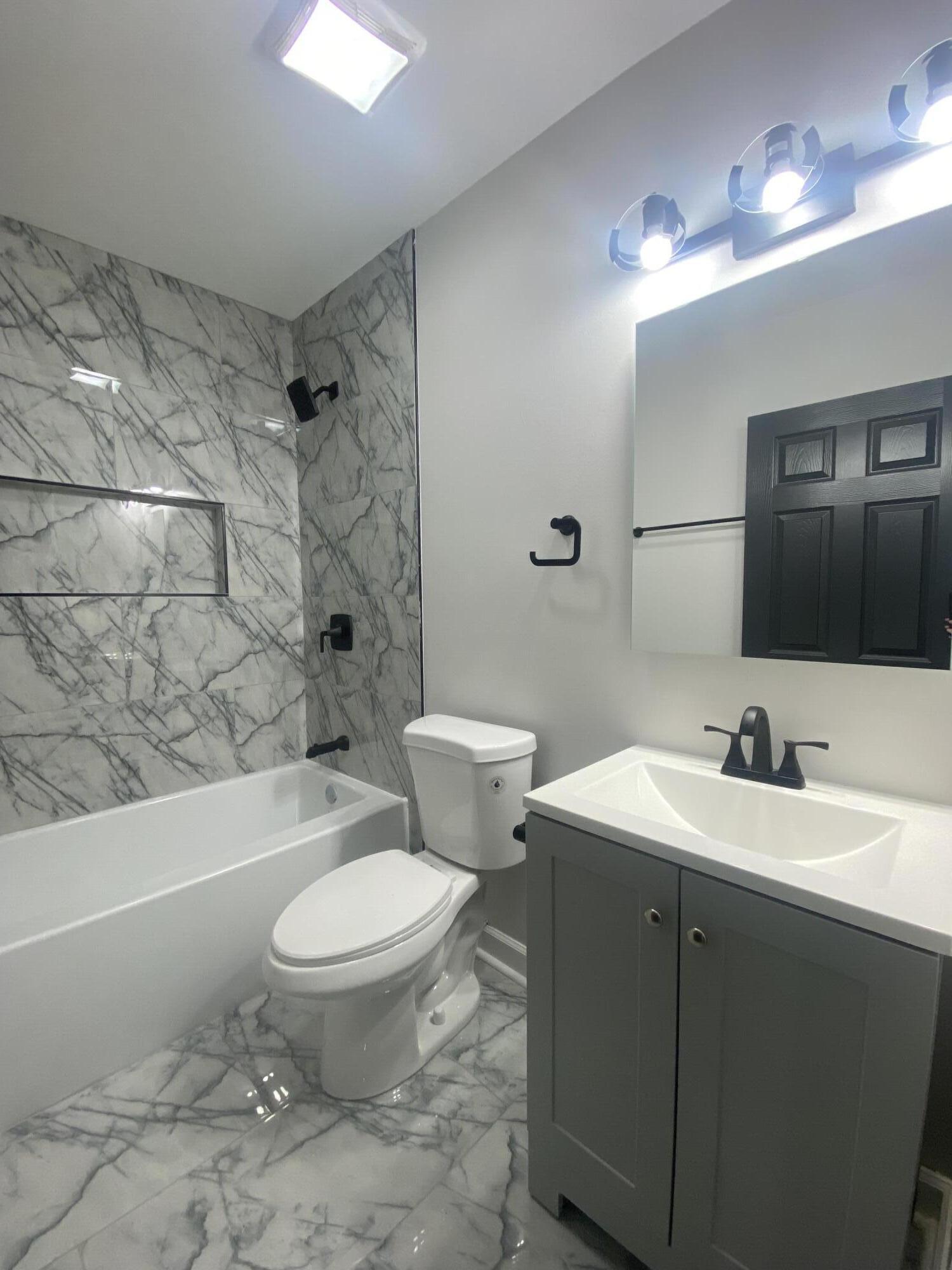 1165 Waite Street Gary, IN 46404 - Photo 8 of 18 a bathroom with a toilet a sink a mirror a bathtub and vanity