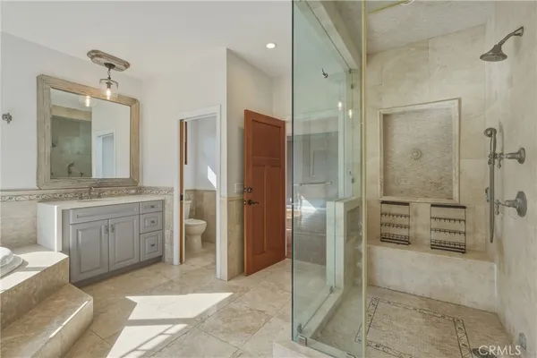 a bathroom with a granite countertop sink mirror and shower