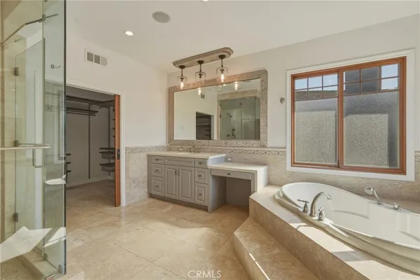a bathroom with a granite countertop tub sink a mirror and a shower