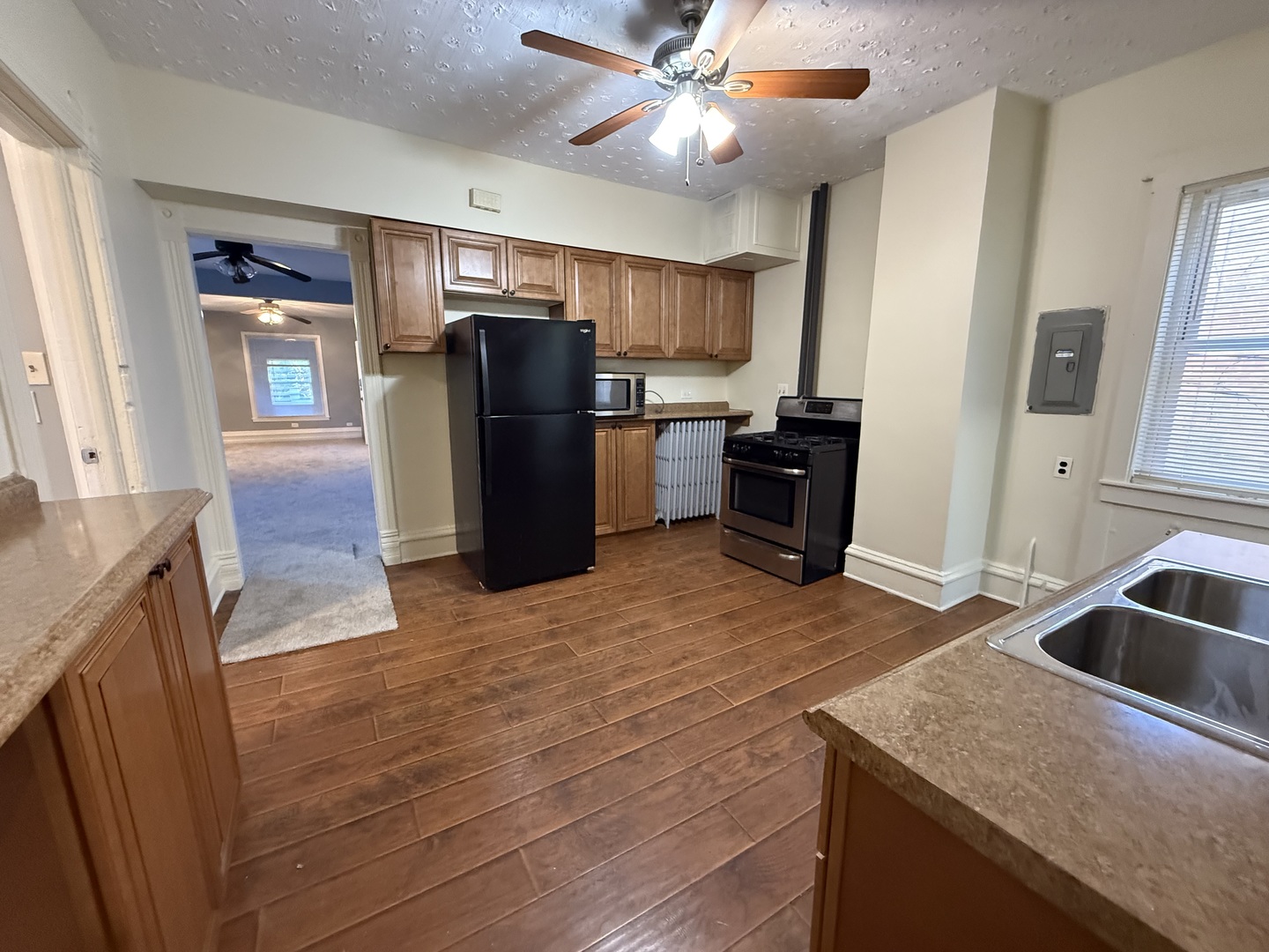 1723 Emerson Street, Unit 1 Evanston, IL 60201 - Photo 9 of 18 a kitchen with stainless steel appliances granite countertop a refrigerator a stove and a sink with wooden floors