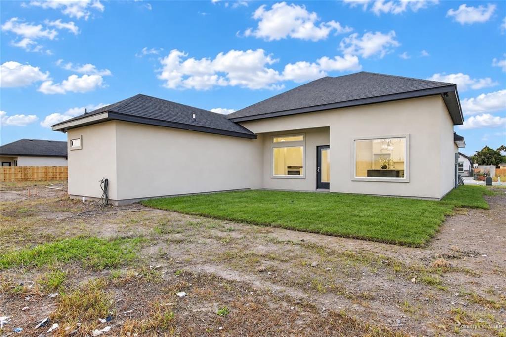 431 Sandy Road Donna, TX 78537 - Photo 20 of 28 Stucco exterior, dark shingle roof, multiple windows, rear exterior door, partial grass lawn