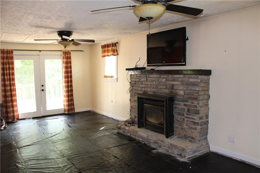 360 Narigon Run Road Claysville, PA 15323 - Photo 6 of 21 This large Living Room features a wood burning stone fireplace and french doors to your deck. It is prepped and ready for the flooring of your choice.