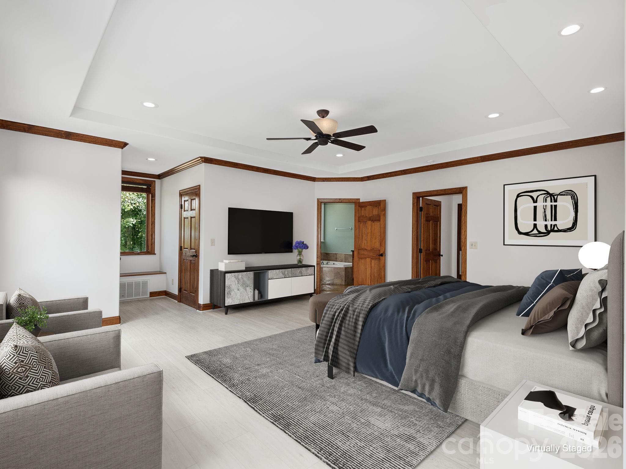 248 Wisdom Cove Road Flat Rock, NC 28731 - Photo 16 of 48 a spacious bedroom with a bed a couch and a flat screen tv