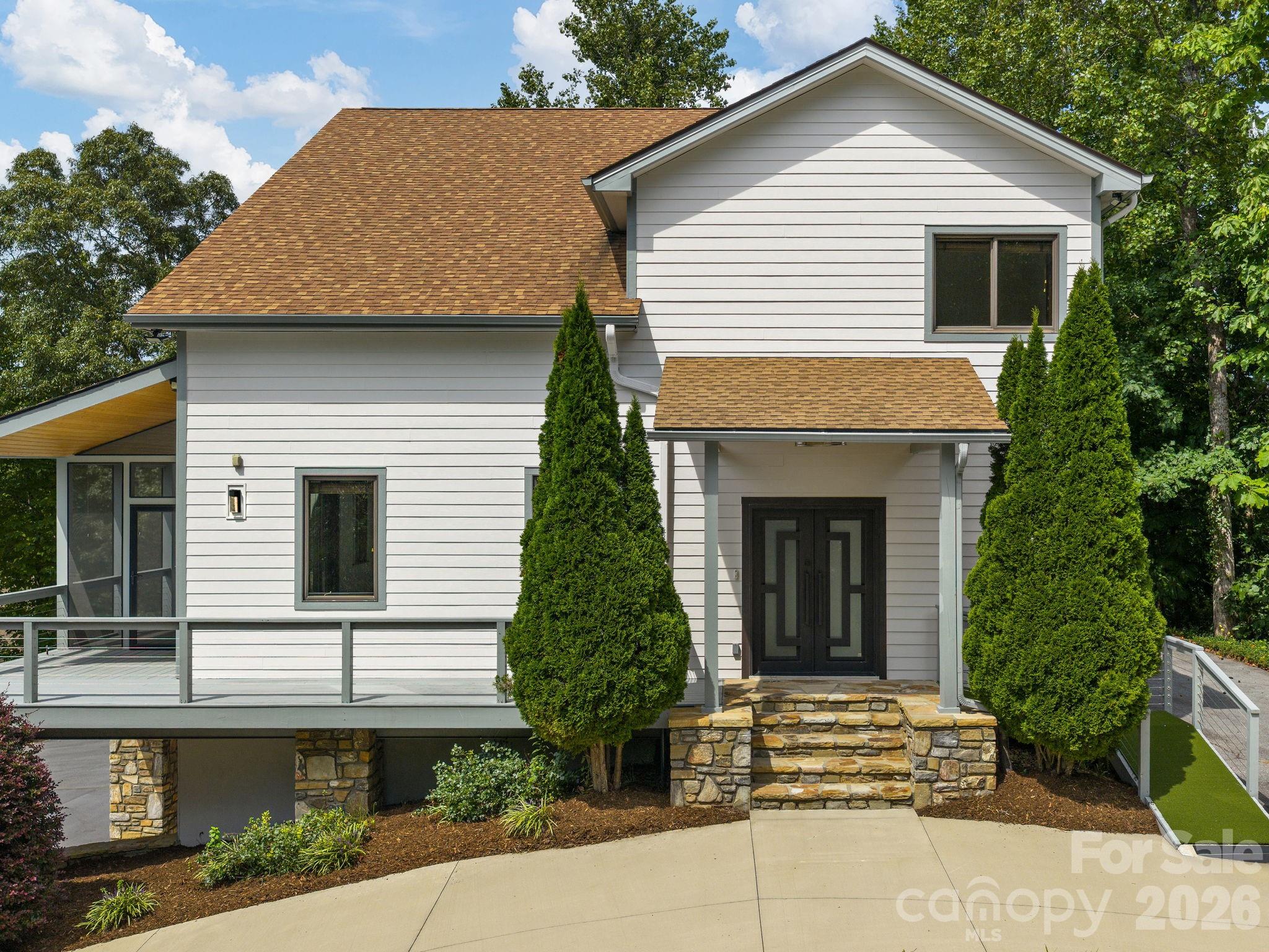 248 Wisdom Cove Road Flat Rock, NC 28731 - Photo 2 of 48 a front view of a house with a garden