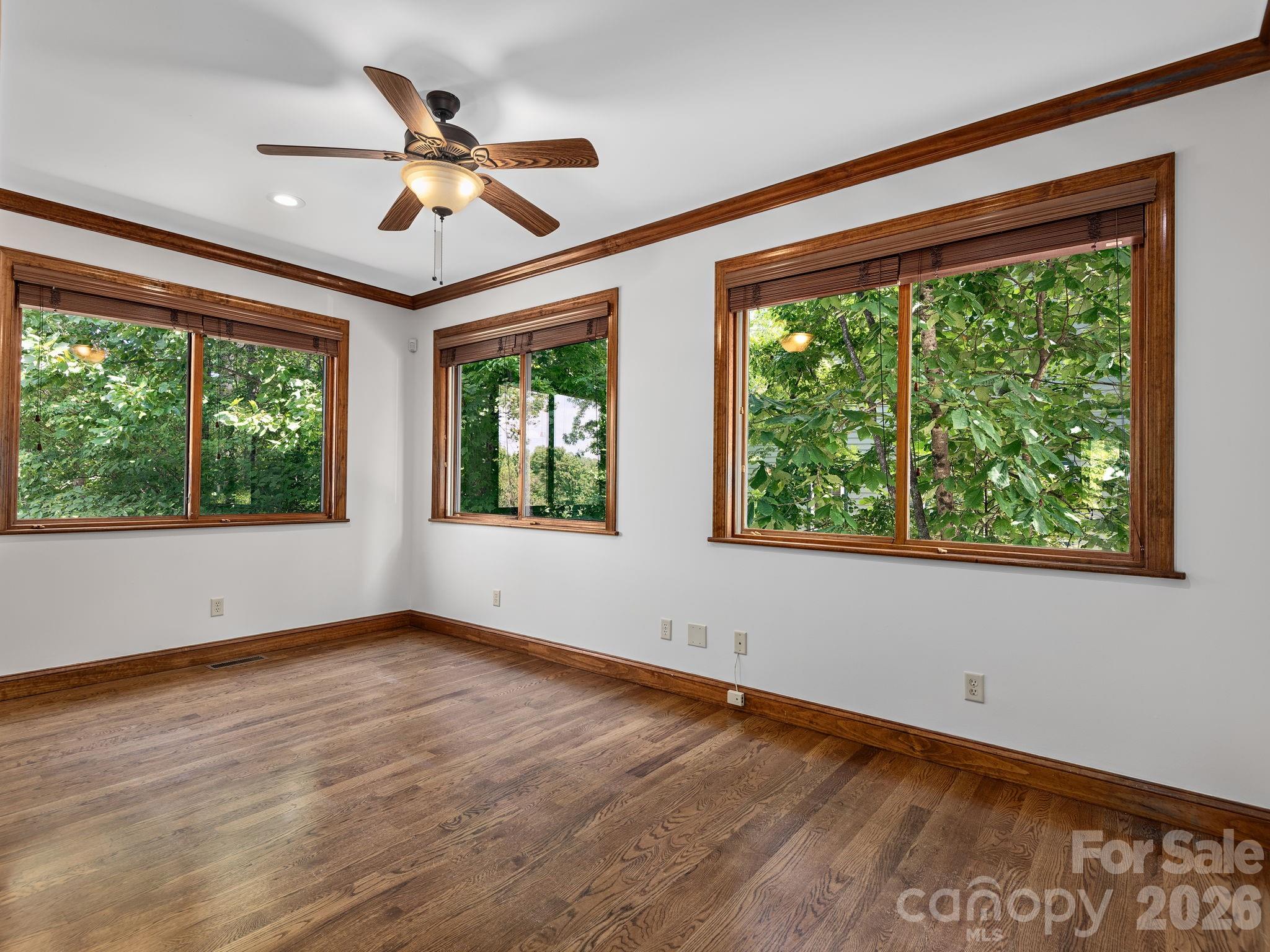 248 Wisdom Cove Road Flat Rock, NC 28731 - Photo 21 of 48 a view of an empty room with wooden floor and a window