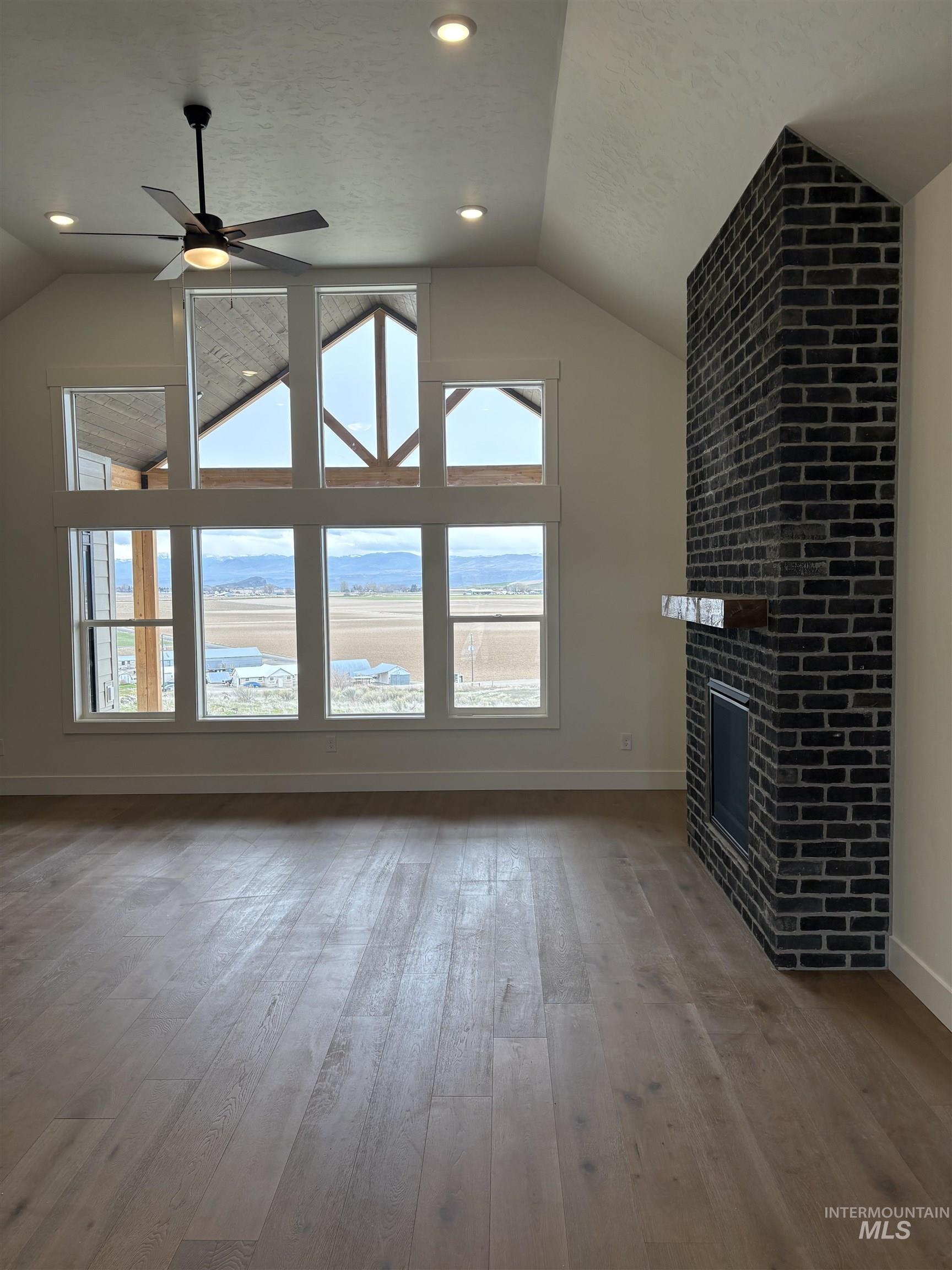 6431 Raptor Ridge Lane Melba, ID 83641 - Photo 12 of 50 Unfurnished living room with a ceiling fan, light wood-style flooring, recessed lighting, a fireplace, and a textured ceiling