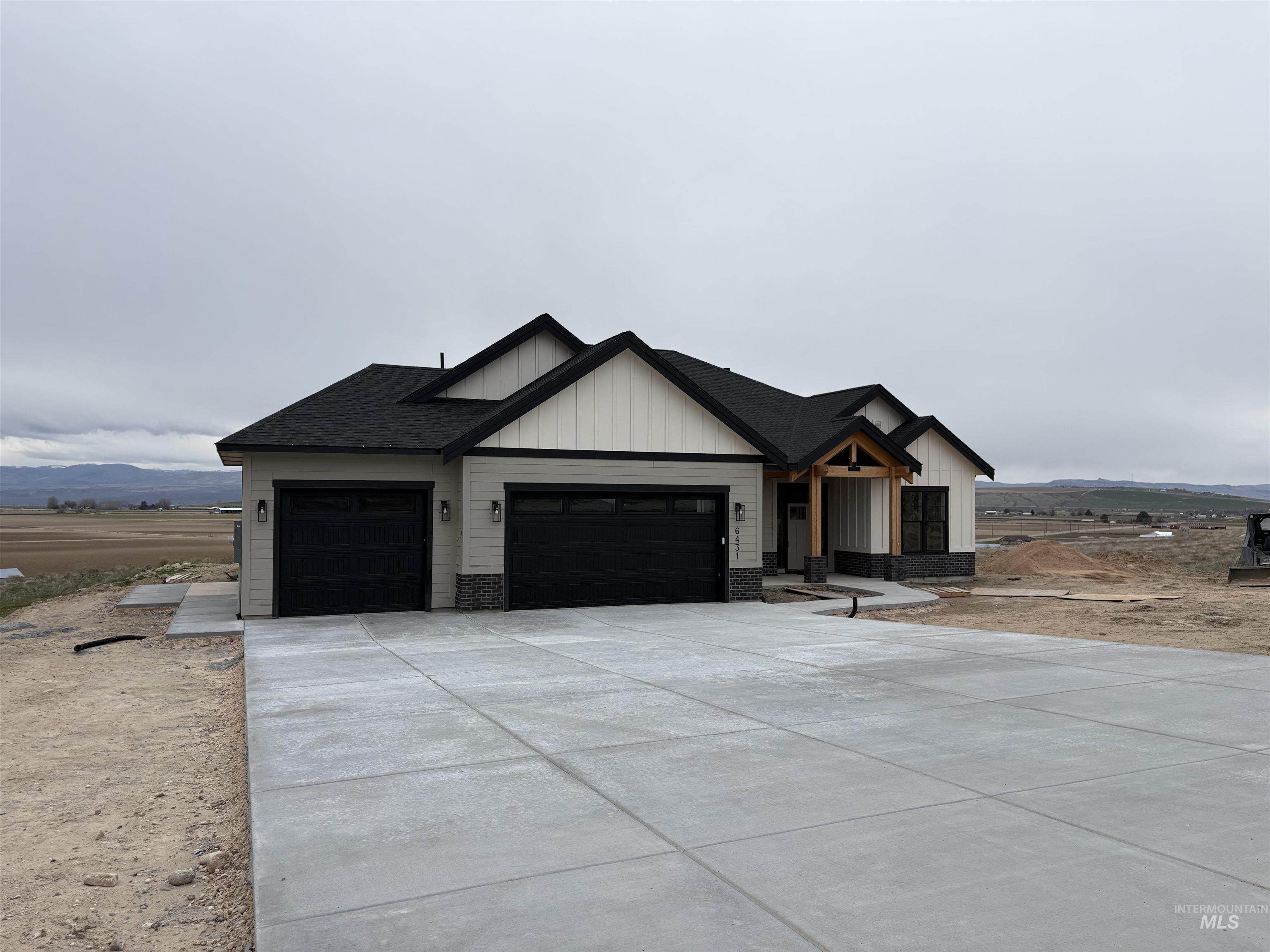 6431 Raptor Ridge Lane Melba, ID 83641 - Photo 2 of 50 Modern farmhouse with an attached garage, driveway, board and batten siding, and a mountain view