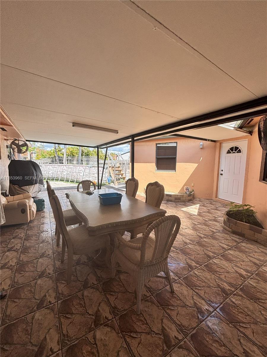 18601 Southwest 98th Avenue Cutler Bay, FL 33157 - Photo 19 of 28 a dining room with furniture and a floor to ceiling window