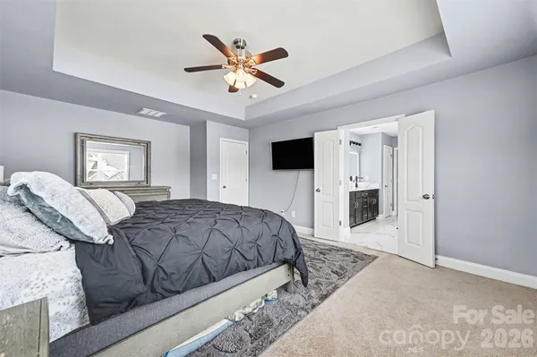 a bedroom with a bed lamp and a chandelier