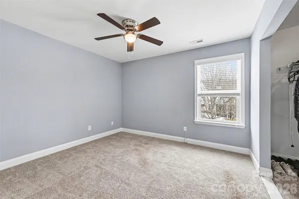 an empty room with fan and windows